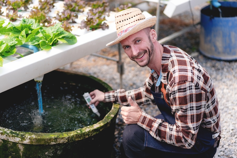 farmer testing water in aquaponics setting 